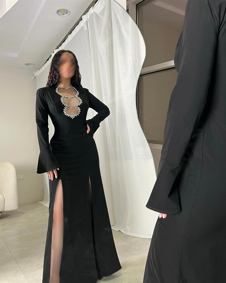 فستان أسود بفتحات مرصعة بالكريستال وفتحة جانبية