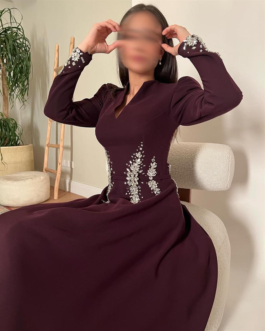 الفستان العنابي بأكمامه المطرزة بالكريستال